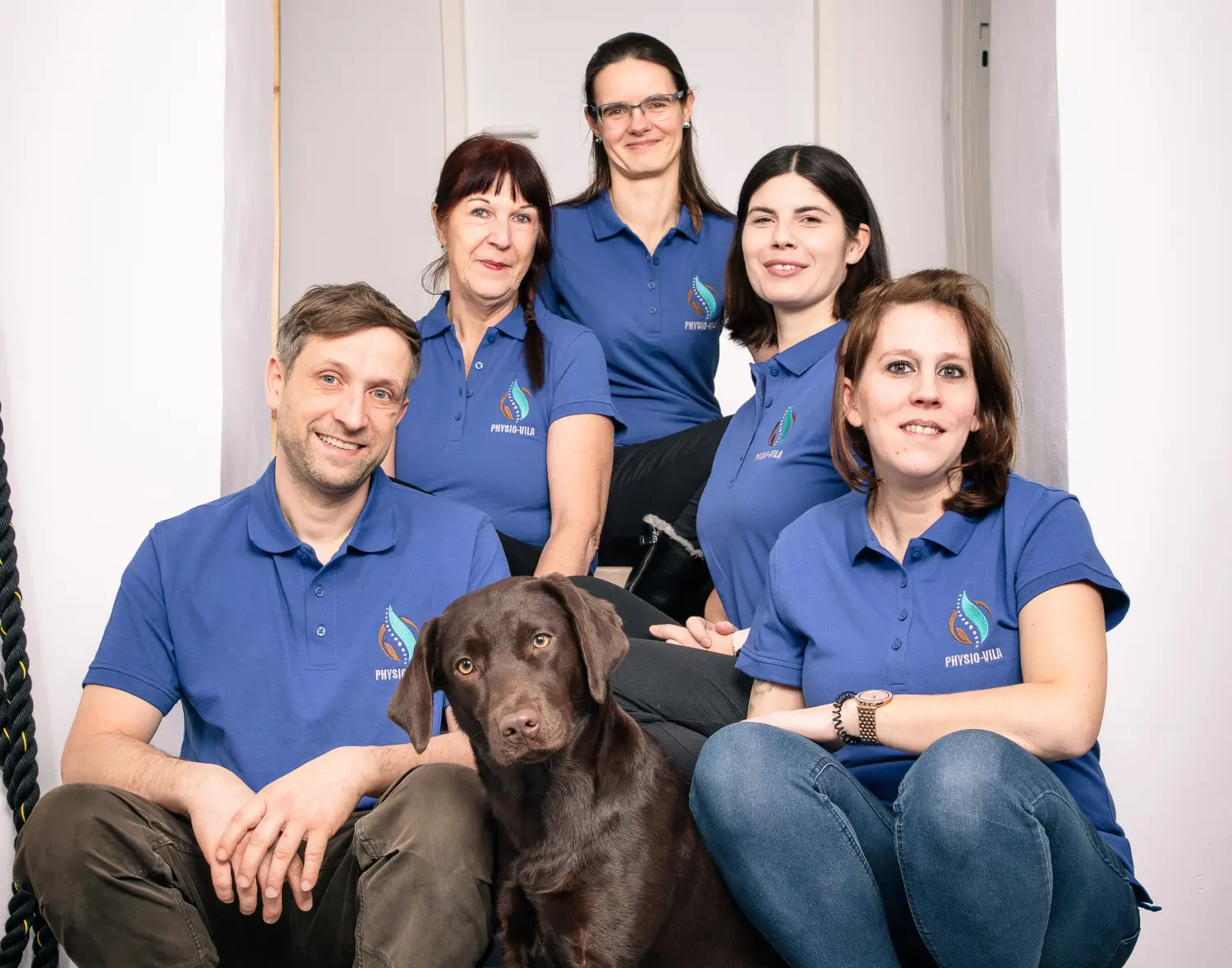 Team von Physio-vila mit einem Hund